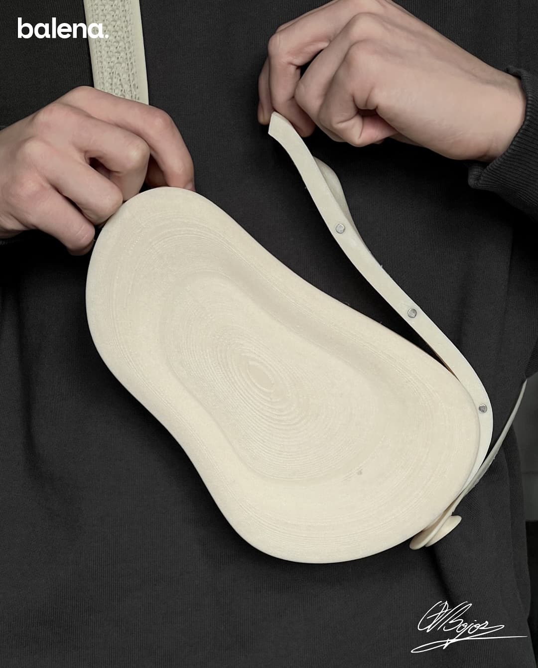 Hands adjusting the ORRA strap, print rings up close