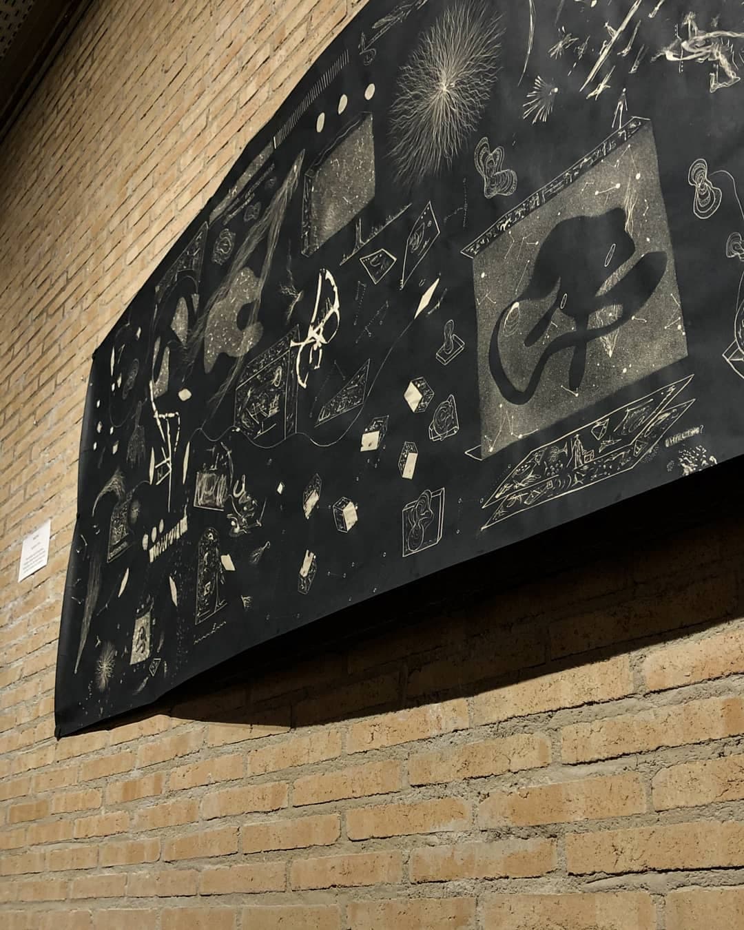 The full length of the panel running down the brick gallery wall