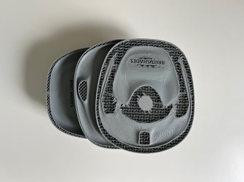 Three printed cases stacked, the top one showing the honeycomb structure inside