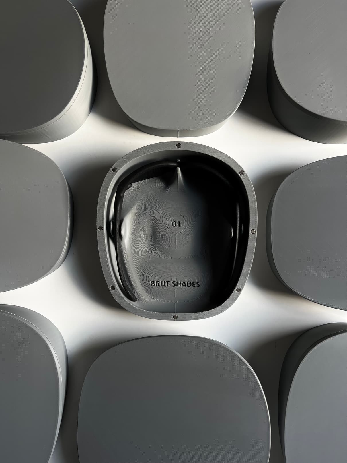 One open case set into a rail of blank grey cases, lit from above