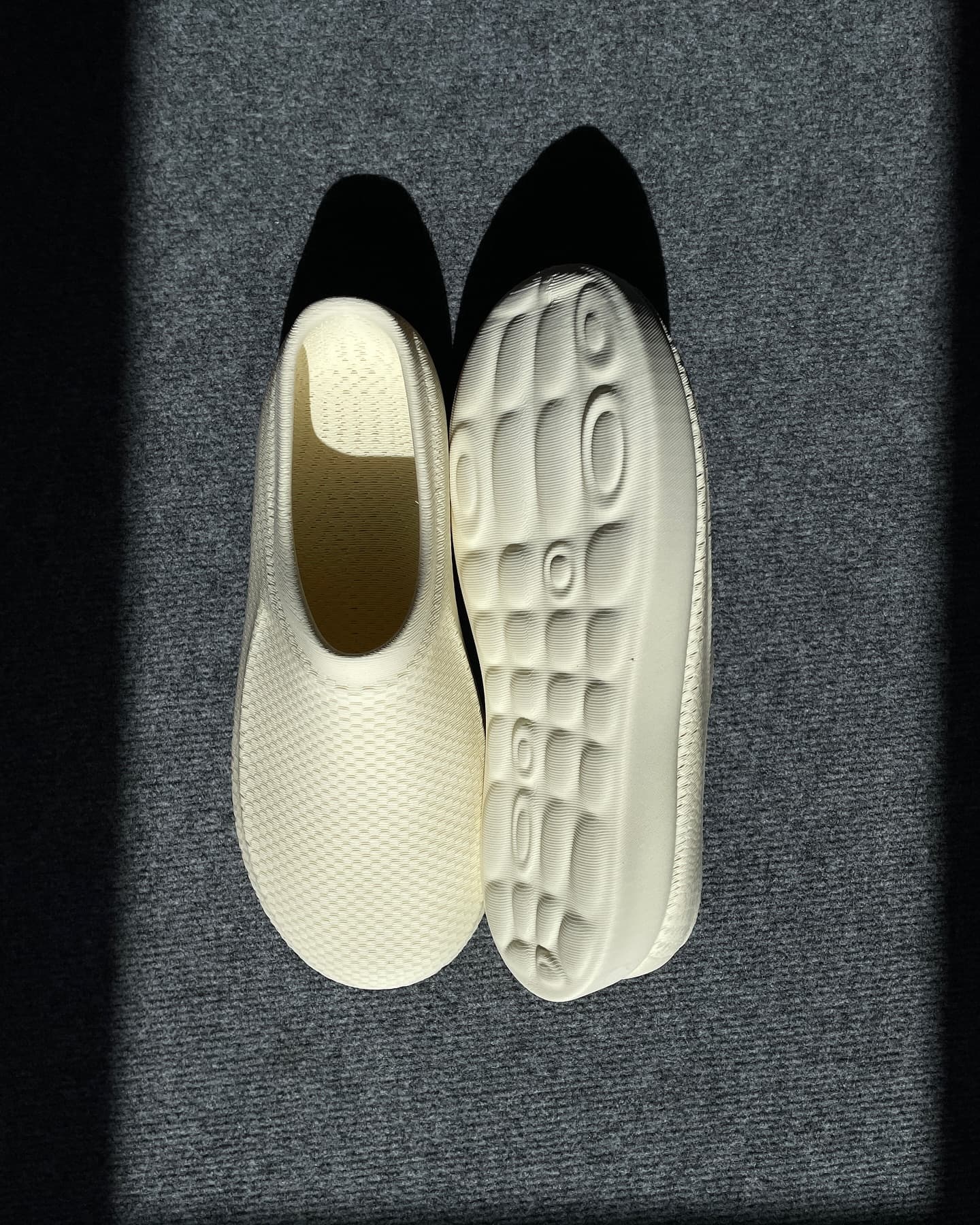 CASUL pair top-down in hard sunlight, one flipped to show the rippled sole
