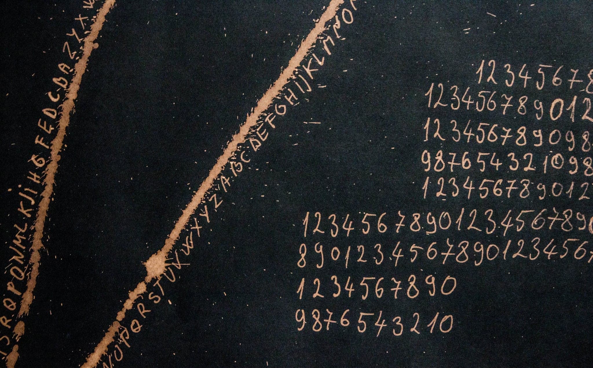 Columns of handwritten numerals beside a beaded arc, on a dark ground.