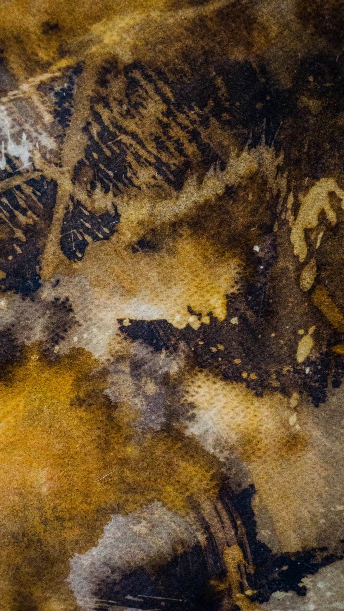 A tall view of the surface, the grain of the paper showing through the gold.