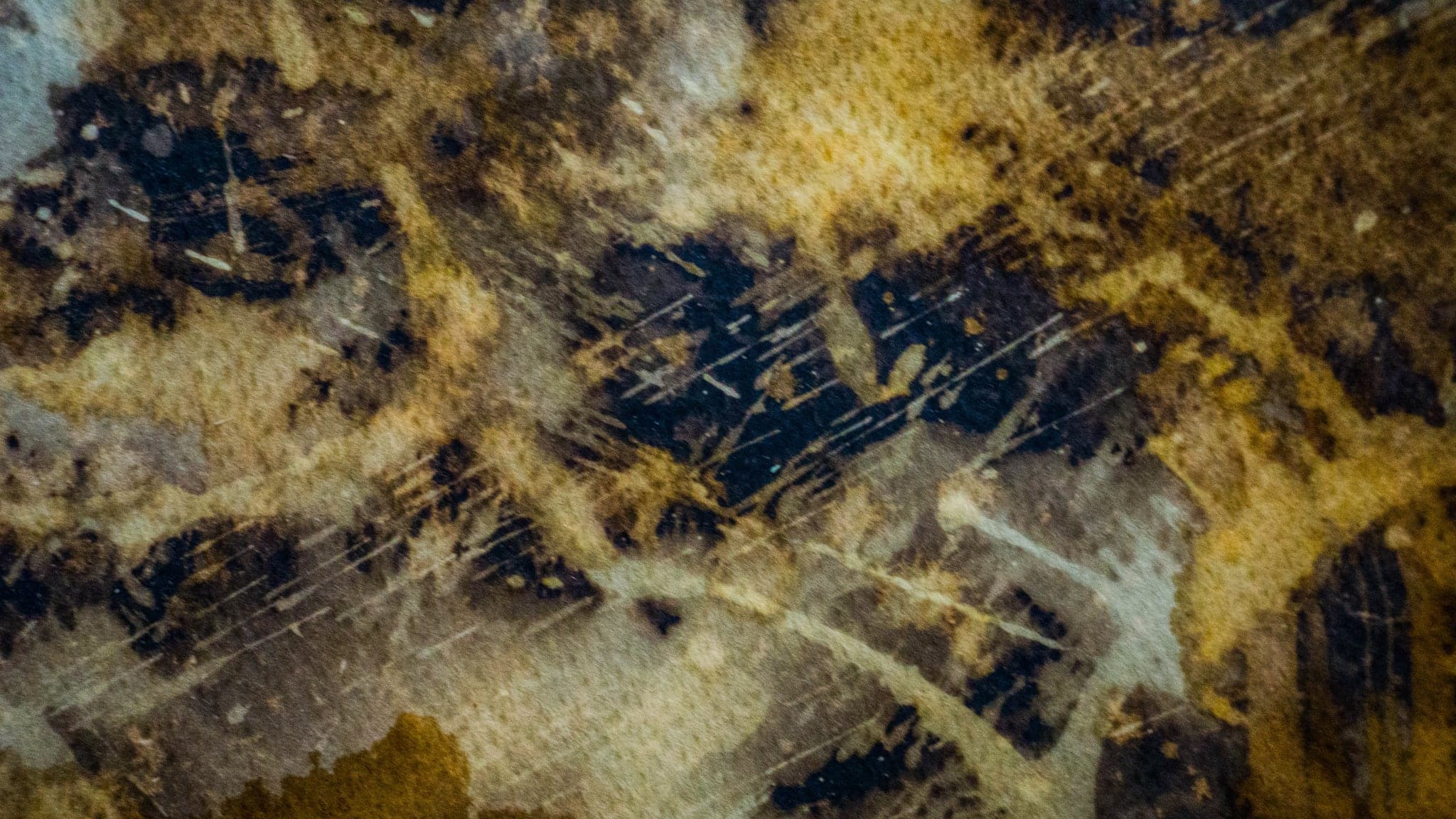 A wide view where the gold thins to ochre and the dark reads as scratched hatching.