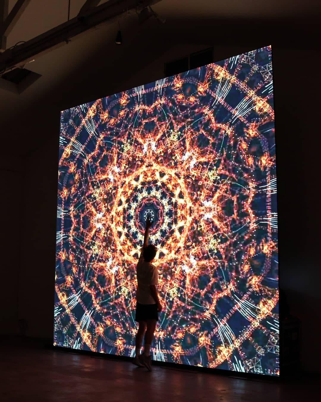 A dense radial field of light filling the gallery wall
