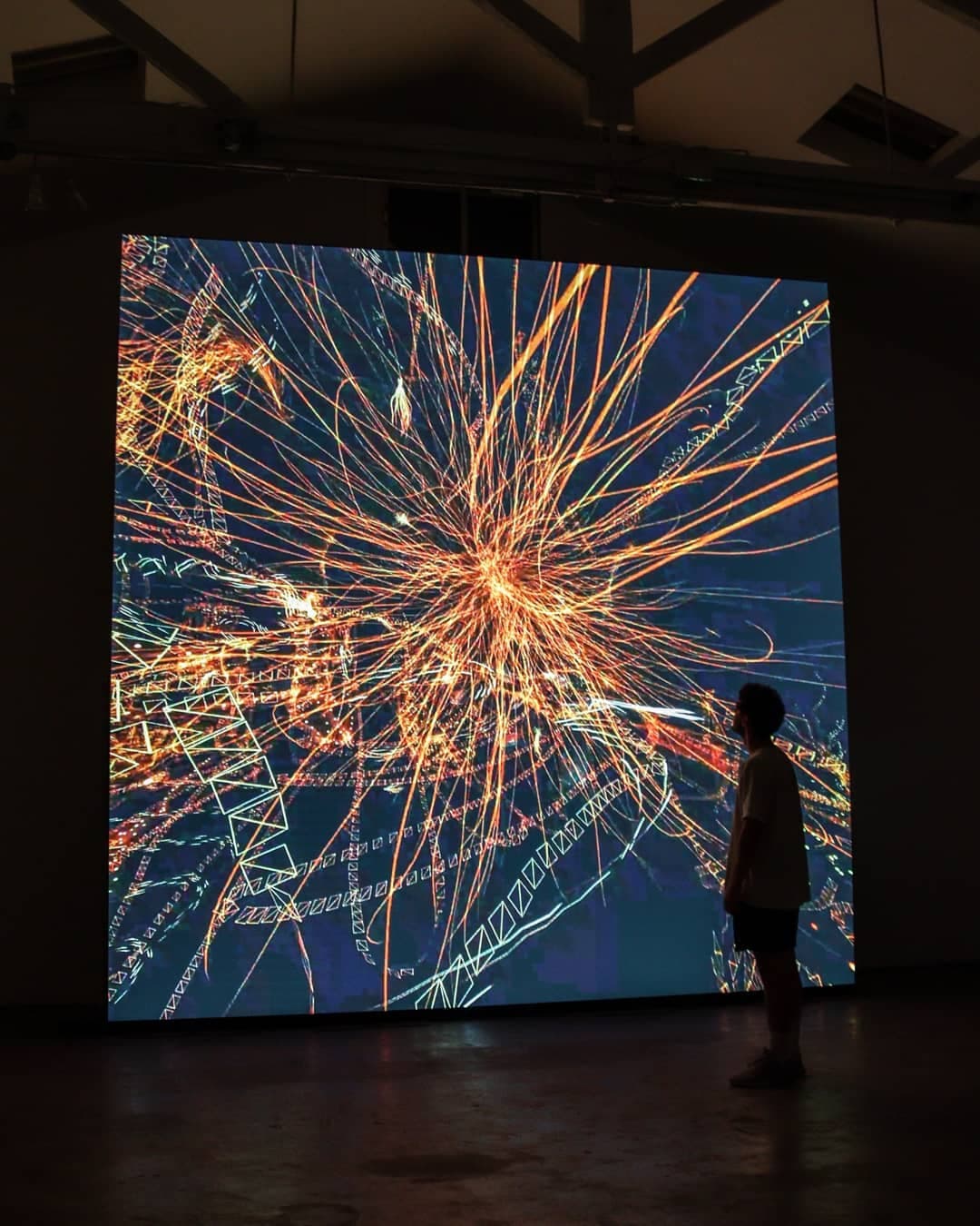Orange filaments throwing outward from a bright centre, a figure watching from the right