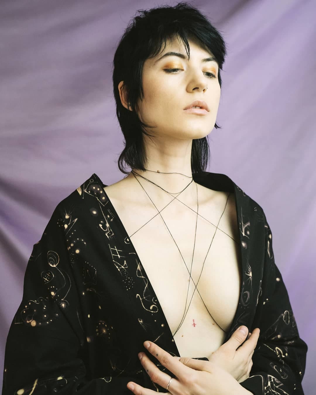 The garment worn open, the gold signs running across the chest and shoulders