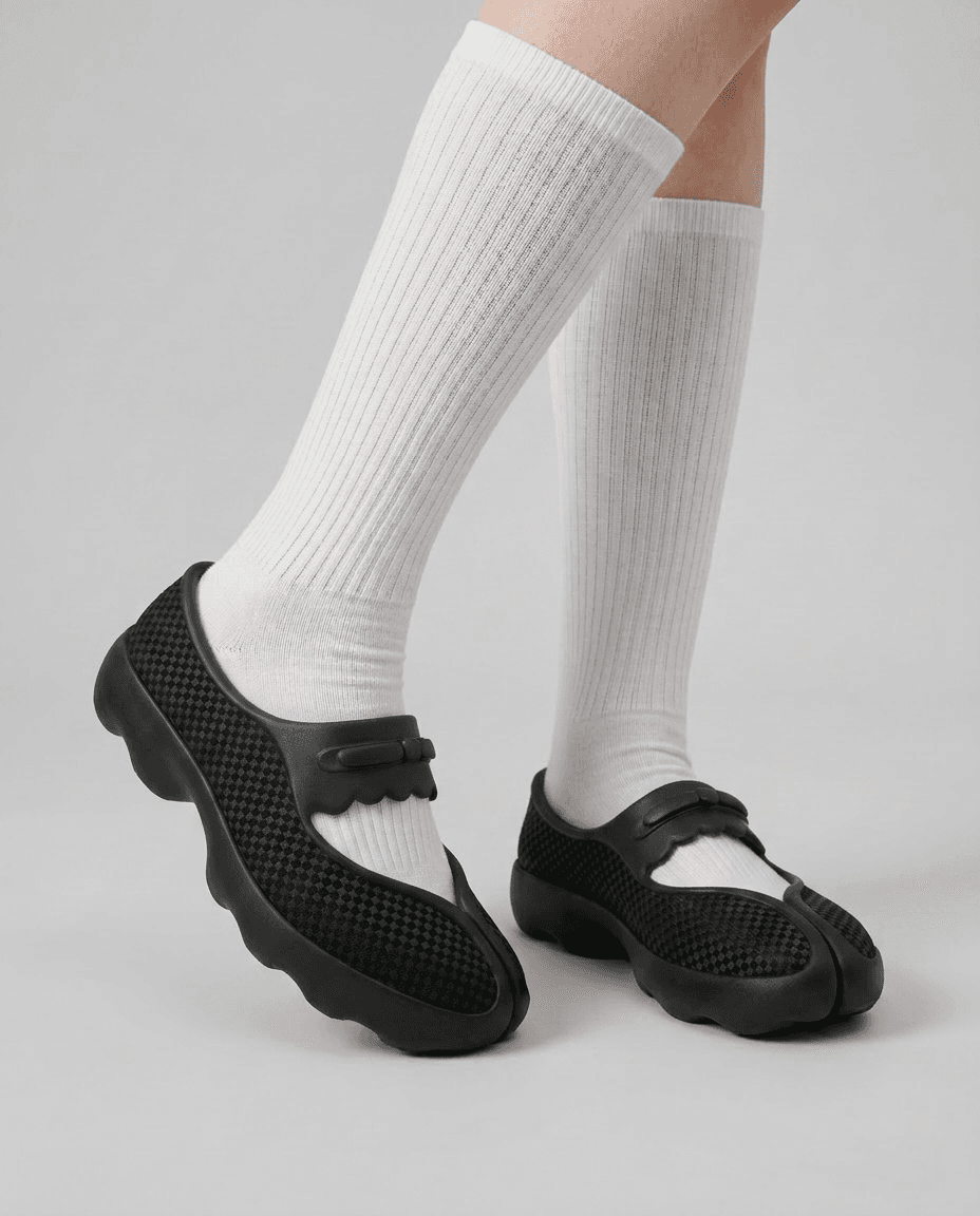 The shoes worn with tall white socks, seen from the side