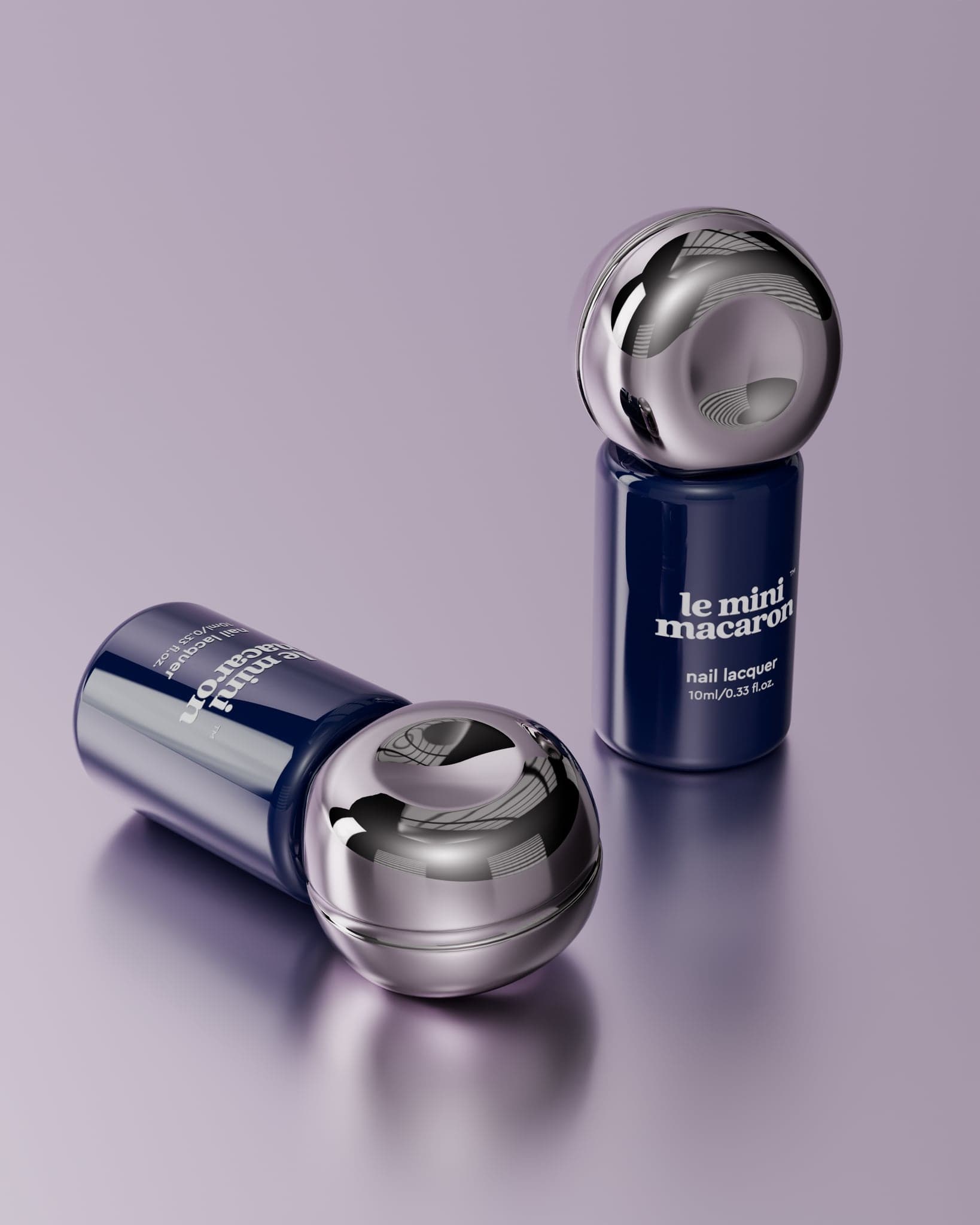 Two navy nail lacquer bottles with chrome spherical caps, one upright and one on its side, on a lilac seamless