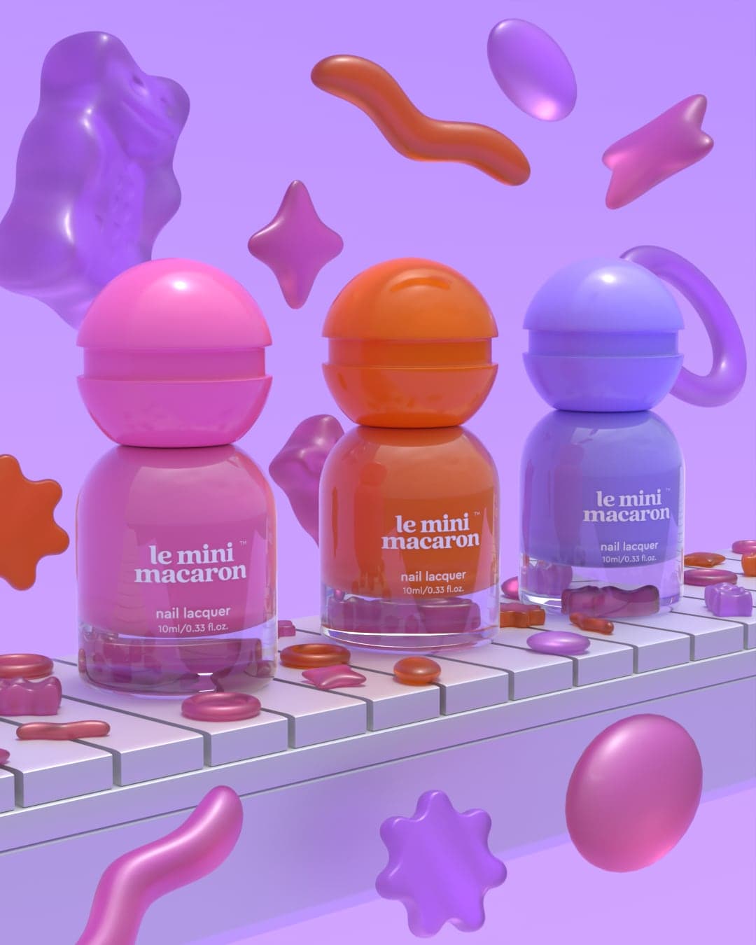 Three nail lacquer bottles, pink, orange and blue, each with a round dome cap, standing on a white belt, with oversized gummy worms, stars and rings floating around them.