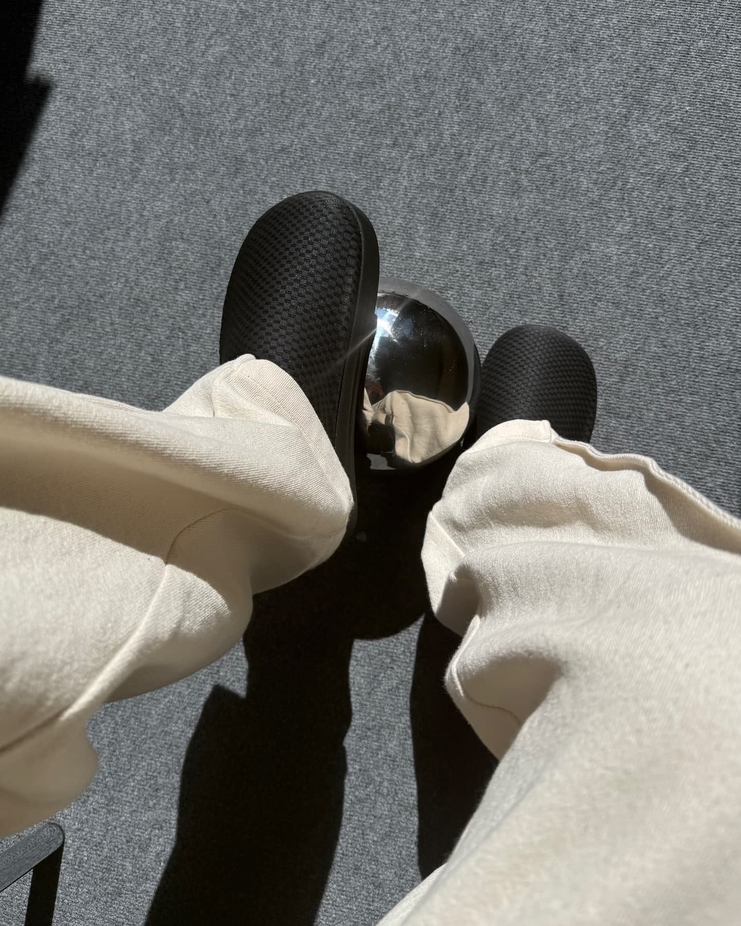 NEVO worn on foot beside a reflective chrome sphere