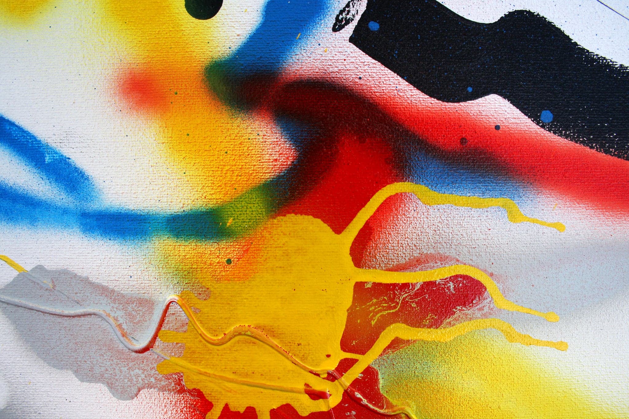 Close view: the black blob above, red and orange fingers running out below it.