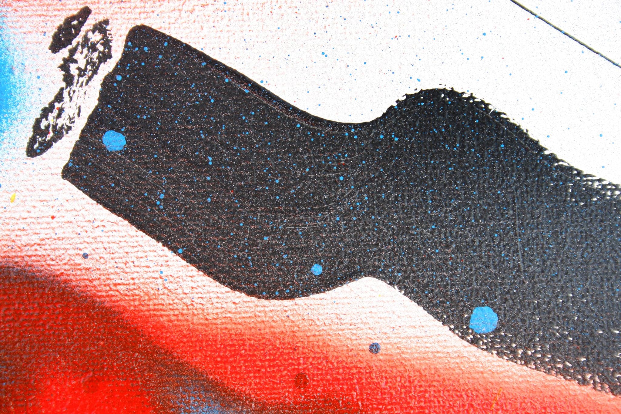 Close view: the black mass with two blue dots on it, a red band beneath.