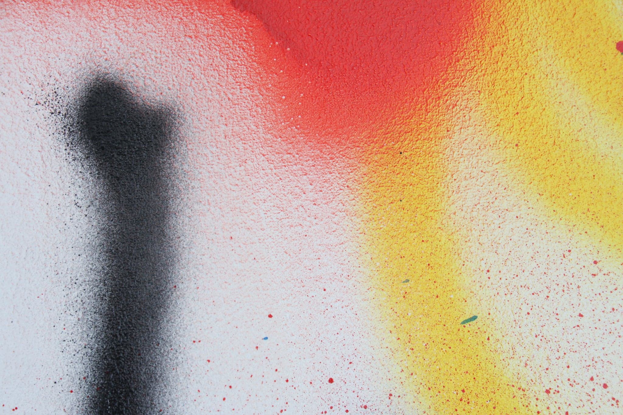 Close view: a black stroke ending in a soft edge, red and yellow bleeding together behind it.