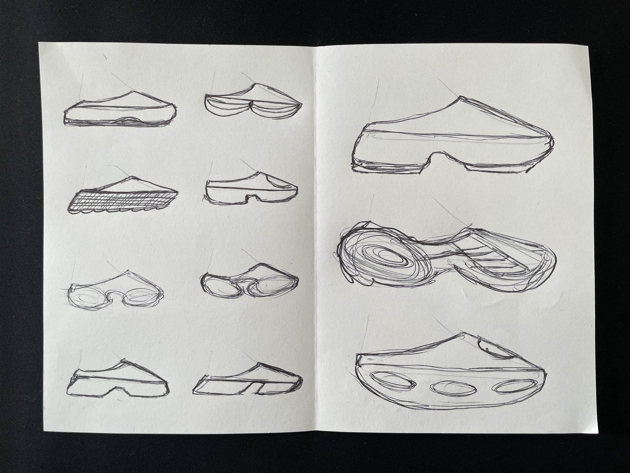 A sketch sheet on black where the lower half breaks into three larger, looser shoe studies