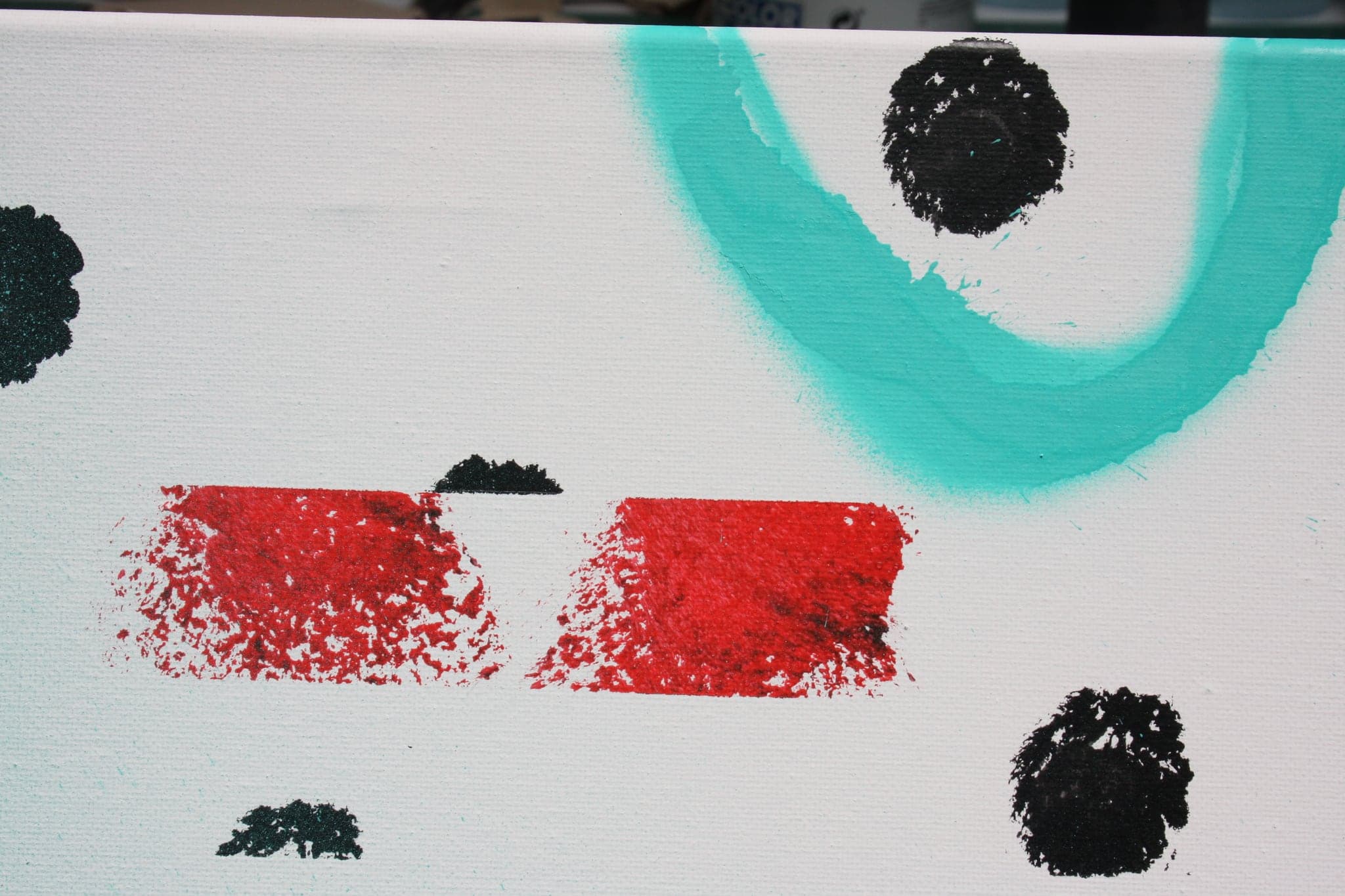 Close view: red rectangles and black dots on white, a turquoise ring at the edge.