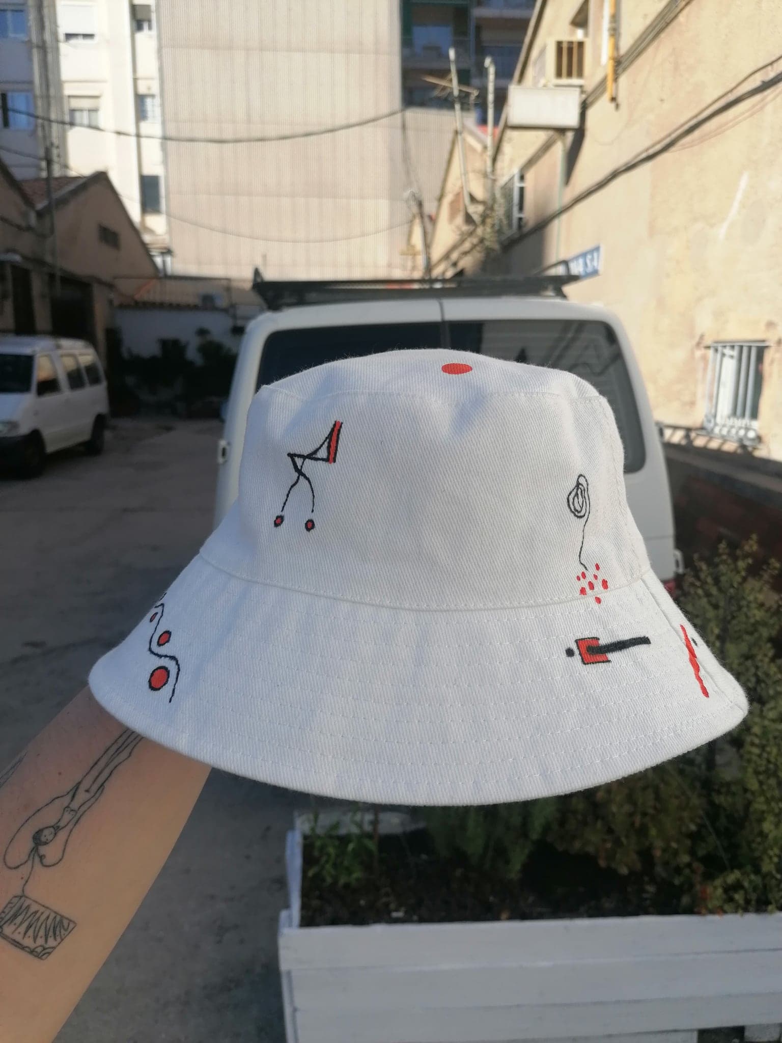 The white hat photographed on a sunlit ledge, a few red and black marks scattered over it