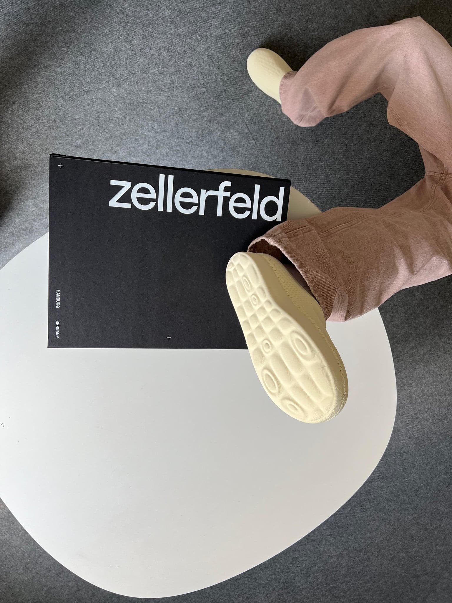 A printed shoe held above a Zellerfeld box, the lattice sole visible